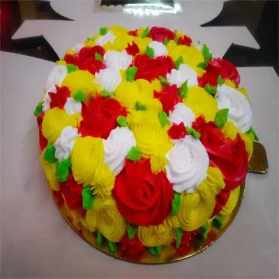 A multi color cake with an inverted cone on top with fondant made candies  on side – Creme Castle